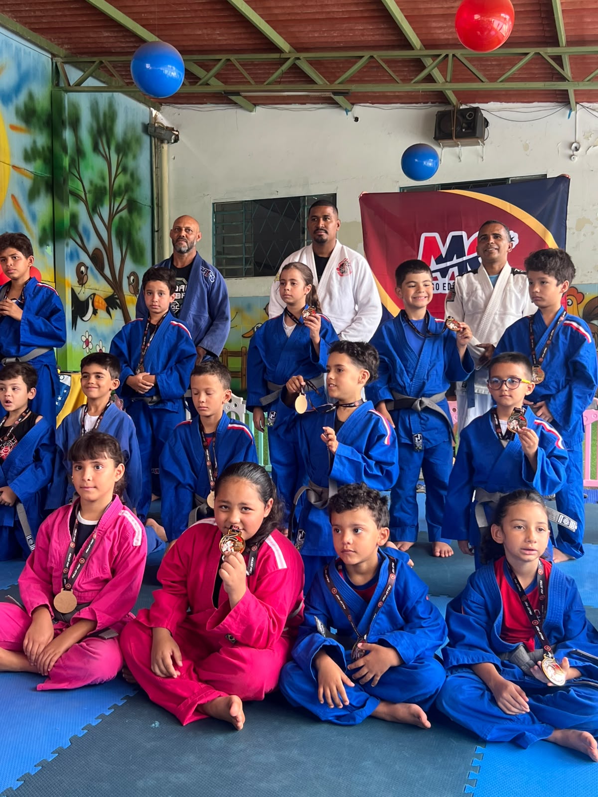 Alunos de jiu-jítsu do Centro Educacional MC exibindo suas medalhas
